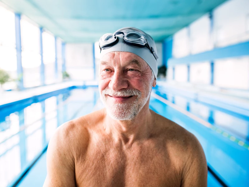 mand som smiler i svømmehal, fordi det har været et godt år for coop opsparing